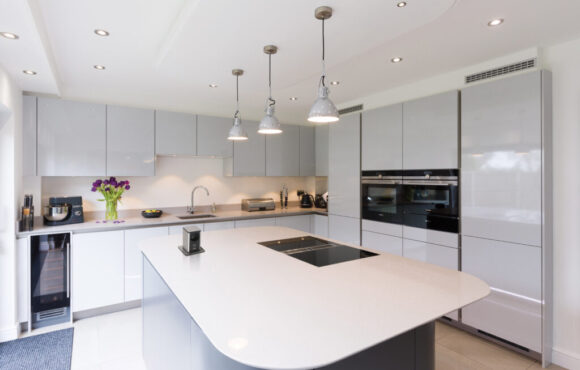 Bela uređena kuhinja sa ostrvom u sredini.