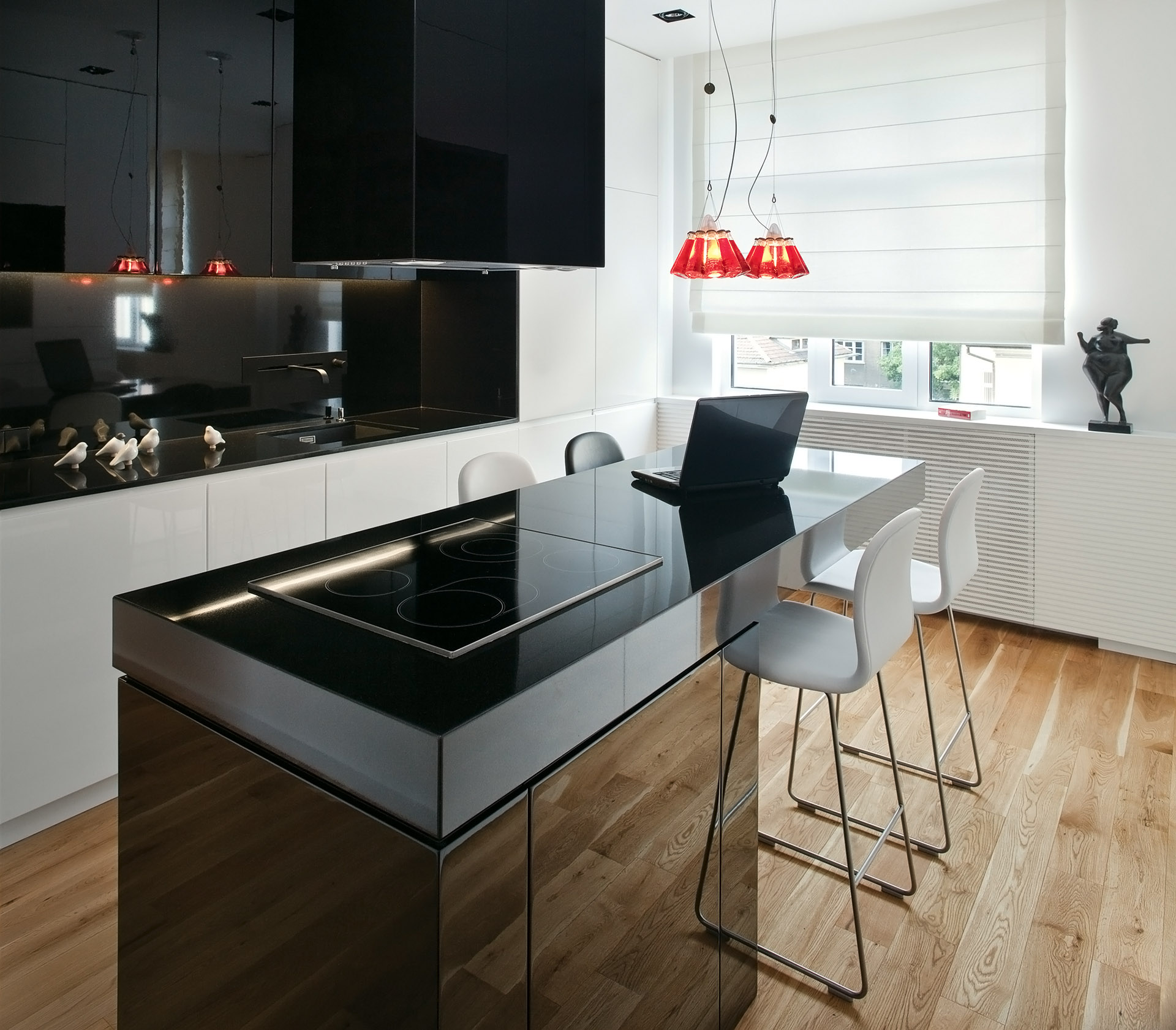 Open concept kuhinja sa crnim šankom i crnim elementima.